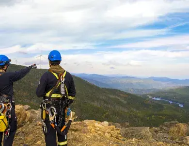 Techniciens et techniciennes face à une éolienne