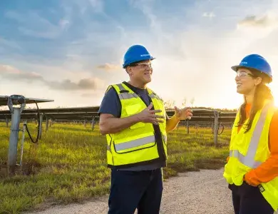 Technicien solaire discutant face à un parc solaire