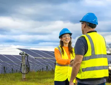 Two persons shaking hands on a solar site, North America