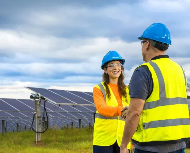 Two persons shaking hands on a solar site, North America